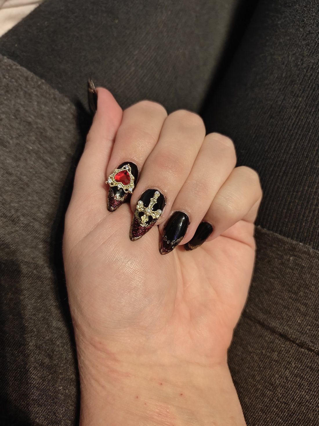 Zwarte stiletto nagels met gouden 3D doodshoofdjes
