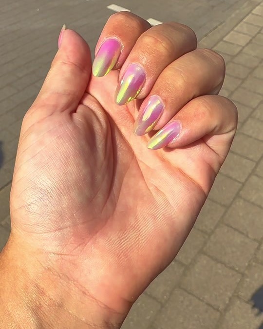 Roze chrome amandelnagels die in de zon geel en groen oplichten
