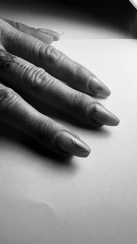 Zwart-witfoto van nagels met dunne chrome lijnen