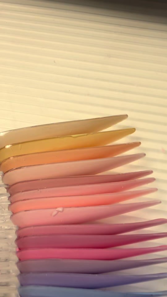 Waaier van nageltips in pasteltinten van geel tot lila